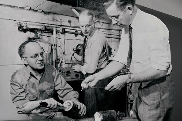 PTFE's inventors, chemists Roy Plunkett (right) and Robert McHarness (center), and engineer Jack Rebok of DuPont reenact the discovery of fluorocarbon polymers. Copyright: Hagley Museum and Library.